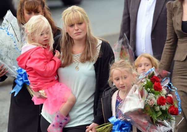 The family of Pc David Phillips, wife Jen and daughters Abigail and Sophie visit the scene in Wallasey where the Merseyside officer was mown down and killed by a stolen car early on Monday.