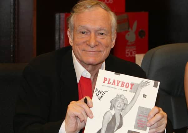 Hugh Hefner signing copies of the Playboy calendar