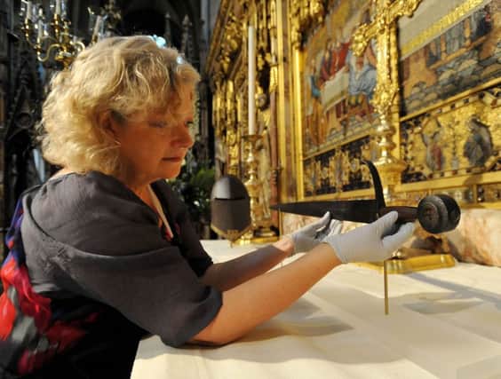 Diana Heath, Metalwork Conservator at Westminster Abbey, adjusts the sword of King Henry V, prior to a service to commemorate the 600th Anniversary of the Battle of Agincourt. The sword was carried through the Abbey at Henry's funeral on 7 November 1422. PRESS ASSOCIATION Photo. Picture date: Thursday October 29, 2015. Photo credit should read: Nick Ansell/PA Wire