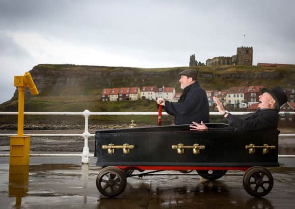 Howard Smith drives Morticia, a velocipede with a side car coffin containing John Fletcher, down Whitby Pier. Picture: Ross Parry Agency