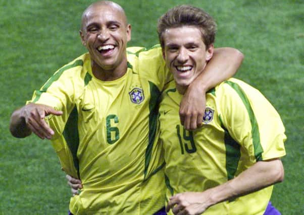 Brazil's Carlos Roberto, left, celebrates with teammate Juninho after he scored the 1-0 during the Brazil versus China, Group C, 2002 World Cup soccer match at the Jeju World Cup Stadium in Seogwipo, South Korea, Saturday June 8, 2002.
