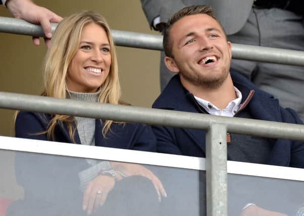 Sam Burgess and his partner watch from the stands during the England's RL Test v France