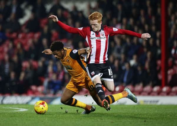 Hull City's Chuba Akpom (left) and Brentford's Ryan Woods battle for the ball at Griffin Park. Picture: Yui Mok/PA