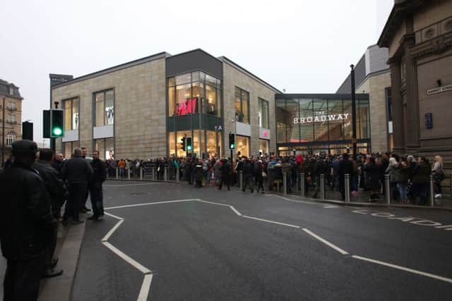 People queue outside the Broadway shopping centre city in Bradford