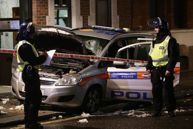 Police officers look at a vandalised police car on Queen Anne's Gate in central London, during the Million Mask March bonfire night protest organised by activist group Anonymous. PRESS ASSOCIATION Photo. Picture date: Thursday November 5, 2015. The London protest is one of many similar marches held worldwide on November 5. Its agenda is broadly anti-capitalism and pro-civil liberty. See PA story POLICE Anonymous. Photo credit should read: Yui Mok/PA Wire