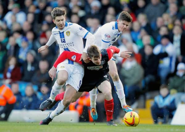 Leeds United's Luke Murphy (left) and Sam Byram (right) tackle Huddersfield's Paul Dixon during the Sky Bet Championship match at Elland Road, Leeds, on February 1, 2014.