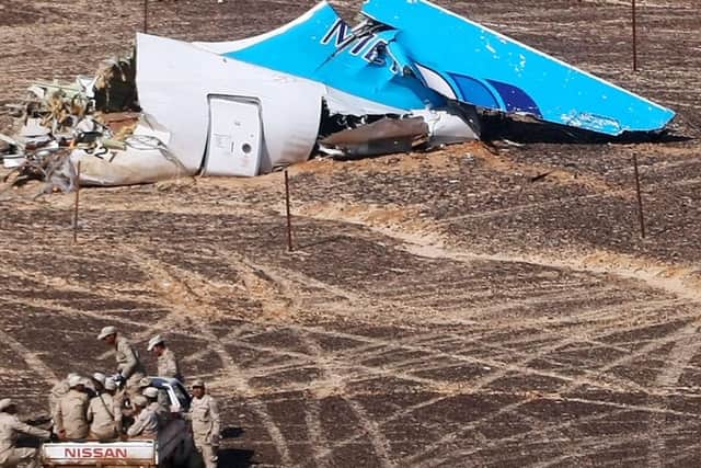 In this photo made available Monday, Nov. 2, 2015, and provided by Russian Emergency Situations Ministry, Egyptian Military on cars approach a plane's tail at the wreckage of a passenger jet bound for St. Petersburg in Russia that crashed in Hassana, Egypt