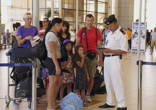British tourists have their documents checked by Egyptian police as they prepare to leave Sharm el-Sheikh. (AP Photo/ Vinciane Jacquet)