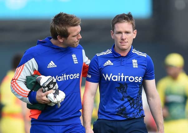 England's Eoin Morgan (right) leaves the pitch after being hit on the helmet by a delivery from Mitchell Starc.