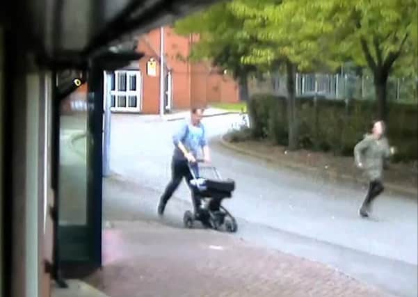 CCTV image showing Kelly Whitworth, followed by Liam Laverick  pushing pram with baby Tommy-Lee inside to hospital.