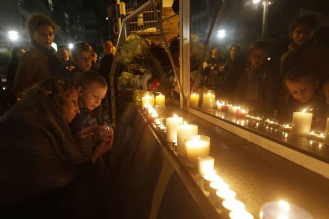 People light candles outside the French embassy in Seoul, South Korea