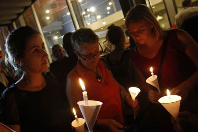 French people living in Thailand hold candles for the victims of Friday's attacks at the Alliance Francaise in Bangkok, Thailand
