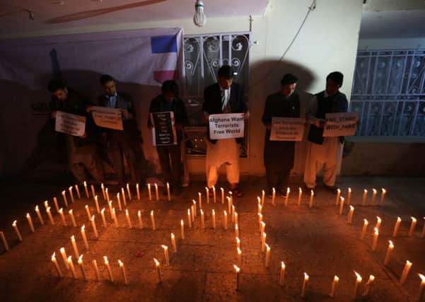 Candles spell out the word peace as Afghan youths and the Solidarity Party of Afghanistan hold a candlelight vigil for the victims of Paris terror attacks in Kabul, Afghanistan