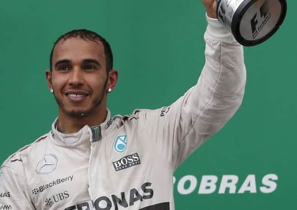 Mercedes driver Lewis Hamilton of Britain, celebrates the podium after finishing second in the Formula One Brazilian Grand Prix. (AP Photo/Silvia Izquierdo)