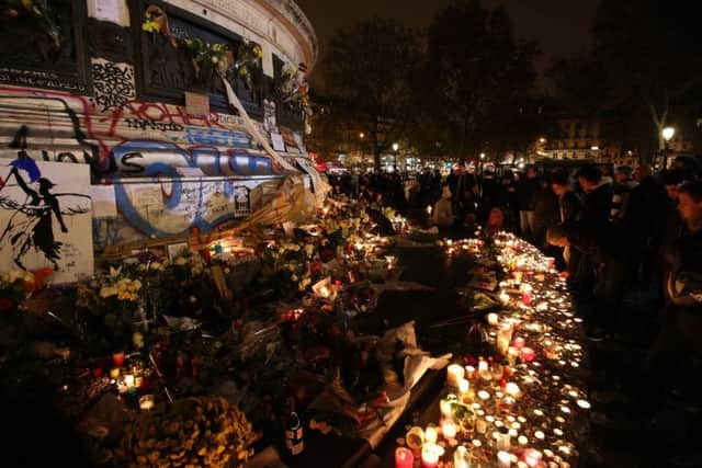 Crowds gather to look at floral tributes and candles left at Place de la Republique (Republic Square), following the terrorist attacks on Friday evening.