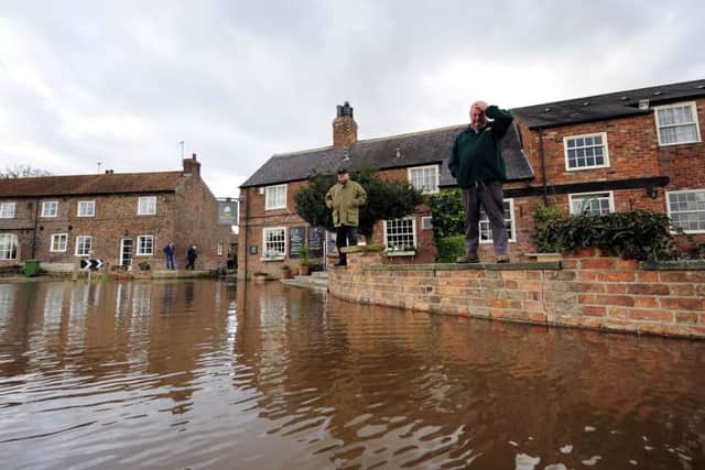 Residents of Acaster Malbis in North Yorkshire watch rising floodwater in the village. PIC: PA