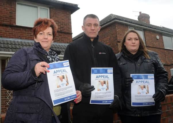 (l-r) Daughter Jackie Perry, grandson Luke Ward and granddaughter Jay Perry hold up appeal posters at the 50 day anniversary press conference appeal for Tommy Ward, on Salisbury Road, Maltby. Picture: Andrew Roe