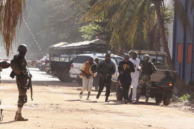 Security force personnel escort people fleeing from the Radisson Blu Hotel in Bamako, Mali