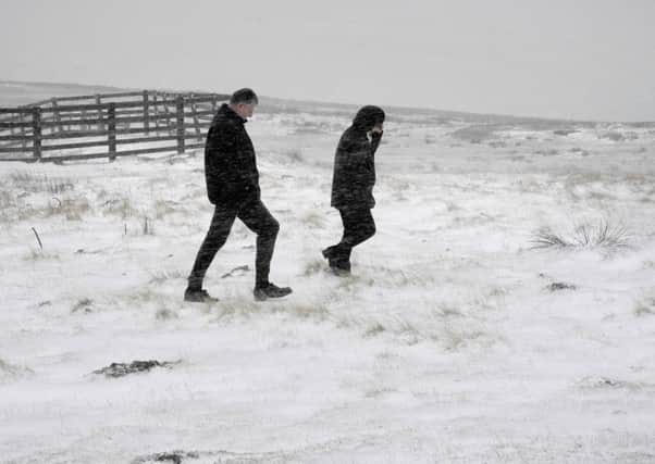 Walkers brave the freezing temperatures and gale force winds on the North Yorkshire Moors above Hutton le Hole, as parts of the UK saw a flurry of snow overnight at the start of a wintry weekend which could see temperatures plummet to minus 5C. PRESS ASSOCIATION Photo. Picture date: Saturday November 21, 2015. Snow showers were reported in parts of Scotland, Wales, northern England and the Midlands. See PA story WEATHER Cold. Photo credit should read: John Giles/PA Wire