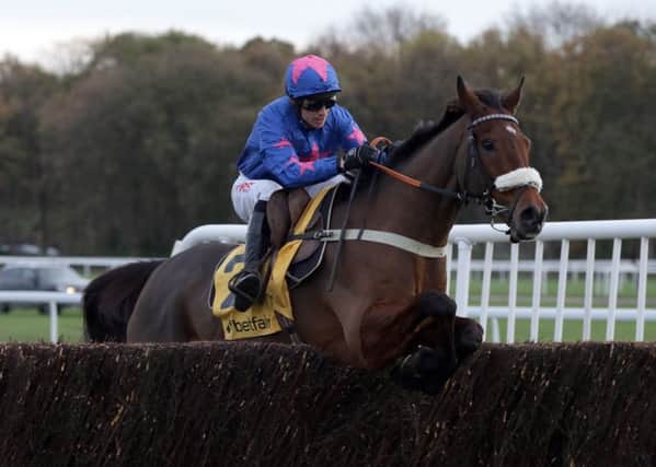 Cue Card, ridden by Paddy Brennan, clears the last hurdle on the way to winning the Betfair Chase at Haydock (Picture: Clint Hughes/PA Wire).