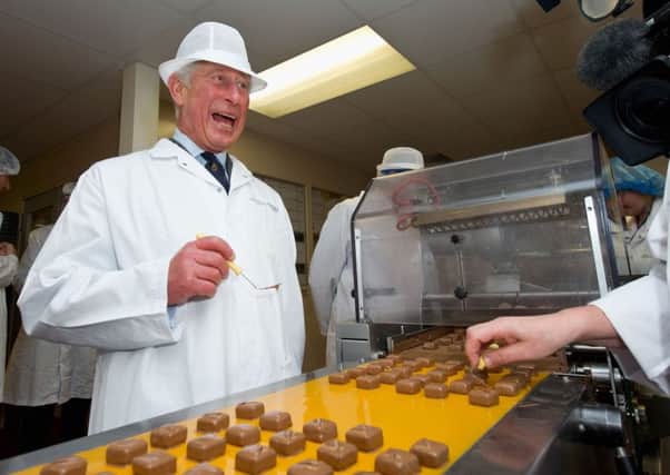 The Prince of Wales decorates chocolates during a tour of The House of Dorchester chocolate factory in Poundbury, Dorset.