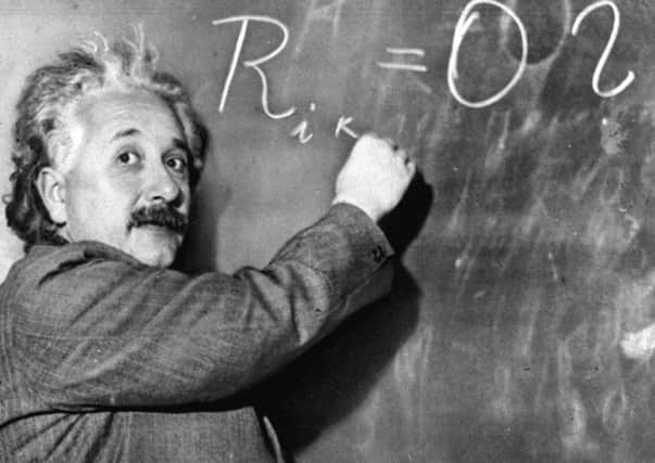 Albert Einstein writes out an equation for the density of the Milky Way on the blackboard at the Carnegie Institute in 1931. (AP Photo)