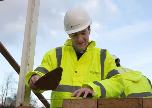 Chancellor of the Exchequer George Osborne lays bricks during a visit to a housing development in South Ockendon in Essex.