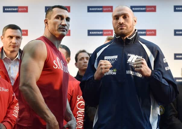 Challenger Tyson Fury, right, and world champion Wladimir Klitschko on the podium after the official weigh-in prior their fight in Duesseldorf (Picture: Martin Meissner/AP).