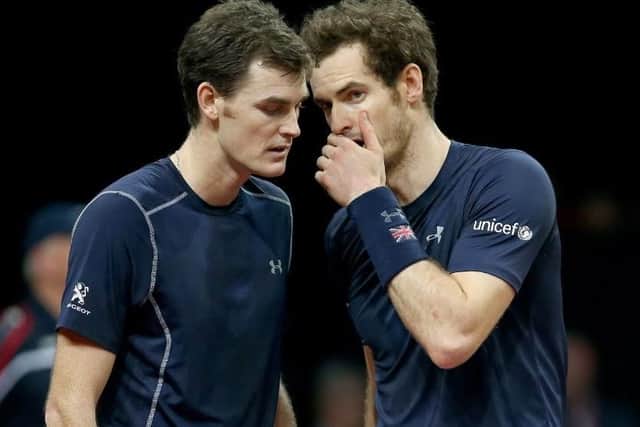 Brothers Andy and Jamie Murray confer during their crucial doubles victory in the Davis Cup final.