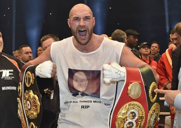 Britain's new world champion Tyson Fury celebrates with the WBA, IBF, WBO and  IBO belts after winning the world heavyweight title fight against Ukraine's Wladimir Klitschko in Duesseldorf. Picture: AP/Martin Meissner.