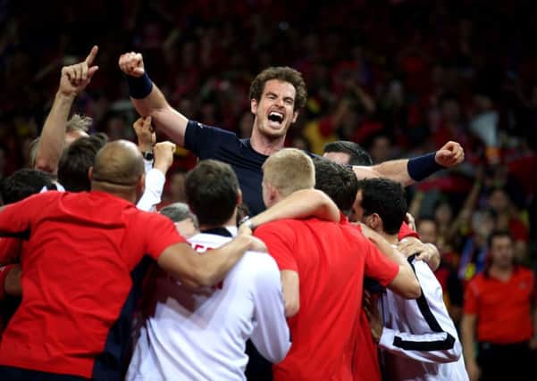 Great Britain's Andy Murray is mobbed by his team-mates after beating David Goffin to win the Davis Cup Final.