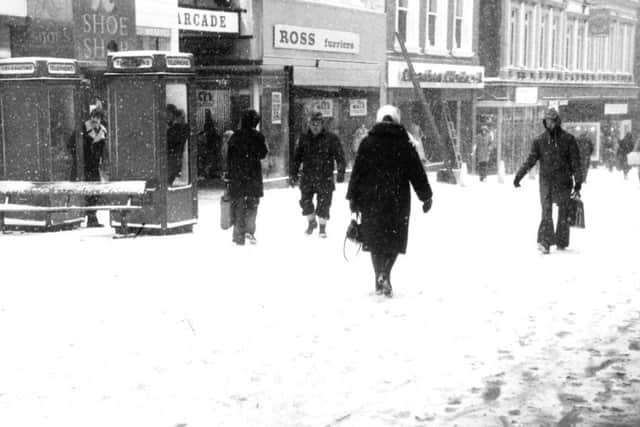Pedestrians struggle through the blizzard in the Leeds precinct, February 1979