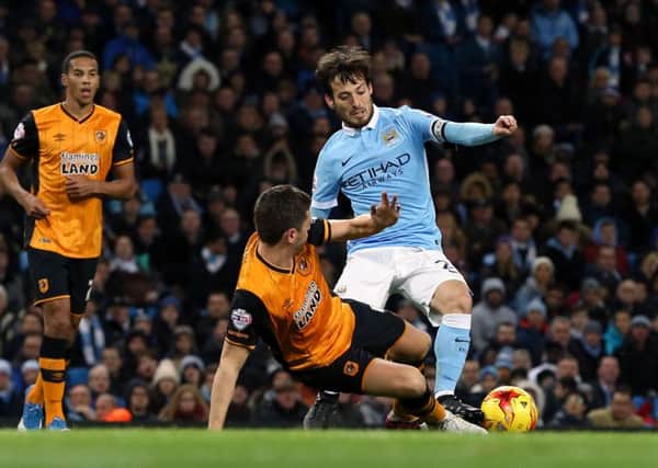 Manchester City's David Silva (right) and Hull City's Alex Bruce battle for the ball at the Etihad Stadium. Picture: PA.