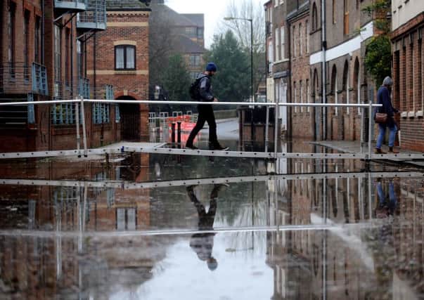 A man walks over a temporary bridge at Skeldergate in York to traverse the high river level.   Picture: Simon Hulme