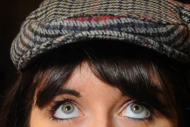 Trying on the latest fashion must-have, a flat cap.