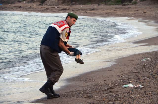 A paramilitary police officer carries the lifeless body ofAylan Kurdi. We have chosen not to reproduce the most widely-shared imaged. (AP Photo/DHA)