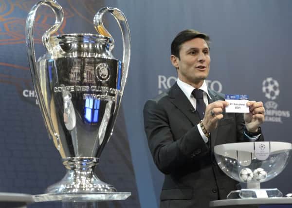 Former Italian international Javier Zanetti, ambassador for the UEFA Champions League final in Milan, shows the ticket of Arsenals last-16 opponents Barcelona at the draw in UEFA headquarters in Nyon, Switzerland (Picture: Laurent Gillieron/Keystone via AP).
