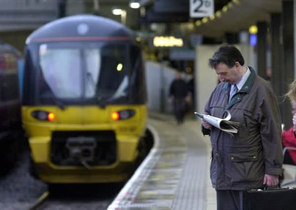A man waits for a train at Leeds City Station.