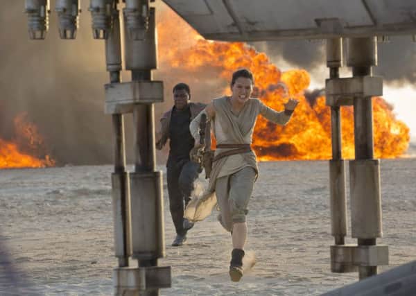 This photo provided by Disney/Lucasfilm shows Daisy Ridley, right, as Rey, and John Boyega as Finn, in a scene from the film, "Star Wars: The Force Awakens," directed by J.J. Abrams. The movie opens in U.S. theaters on Dec. 18, 2015. (David James/Disney/Lucasfilm via AP)