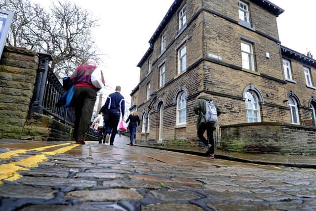 Members of the public leaving Saltaire Station, making their walk up the cobbled street of Albert Terrace.