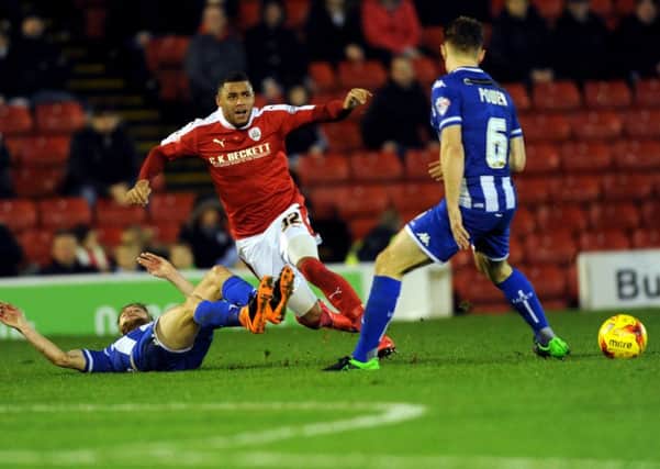 Barnsley's Reece Wabara is brought down by Wigan's Michael Jacobs.
 (Picture: Jonathan Gawthorpe)