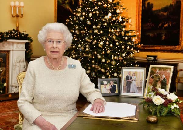 Queen Elizabeth II is pictured sitting at a desk in the 18th Century Room at Buckingham Palace, London, after recording her Christmas Day broadcast to the Commonwealth. Credit: John Stillwell/PA Wire