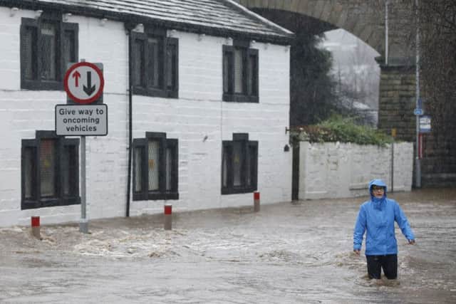 People wade through flood waters at Mytholmroyd in Calderdale, West Yorkshire, where flood sirens were sounded after torrential downpours. (Picture: Peter Byrne/PA Wire)