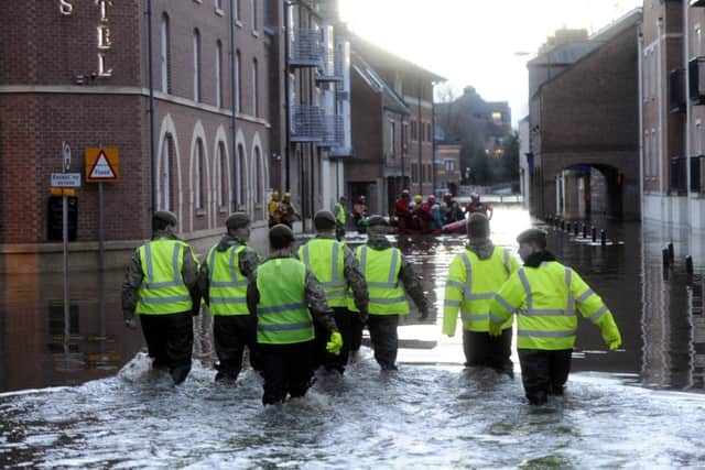 Members of the Army and rescue teams help evacuate people from flooded properties after they became trapped by rising floodwater when the River Ouse bursts its banks in York city centre. (John Giles/PA Wire)
