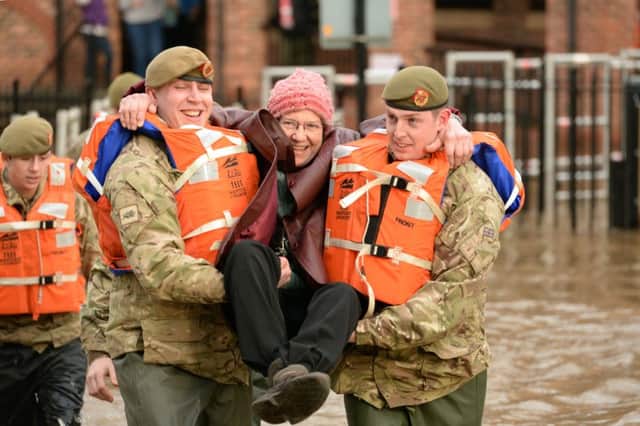 Handout photo issued by the MoD of  members of 2 LANCS, going to the aid of a local resident, as she is carried out of her home in York, as swamped towns and cities continue to struggle against the Christmas floods. PRESS ASSOCIATION Photo. Picture date: Monday December 28, 2015. With more rain forecast for the middle of the week there may be worse to come and the Environment Agency (EA) has more than 25 severe flood warnings in place - meaning there is still a danger to life. See PA story WEATHER Floods. Photo credit should read: SSgt Mark Nesbit RLC (Phot)/MoD Crown Copyright/PA Wire  NOTE TO EDITORS: This handout photo may only be used in for editorial reporting purposes for the contemporaneous illustration of events, things or the people in the image or facts mentioned in the caption. Reuse of the picture may require further permission from the copyright holder.