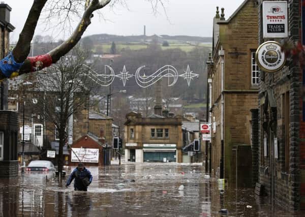 A man wades through flood waters at Hebden Bridge in West Yorkshire, where flood sirens were sounded after torrential downpours. Peter Byrne/PA Wire