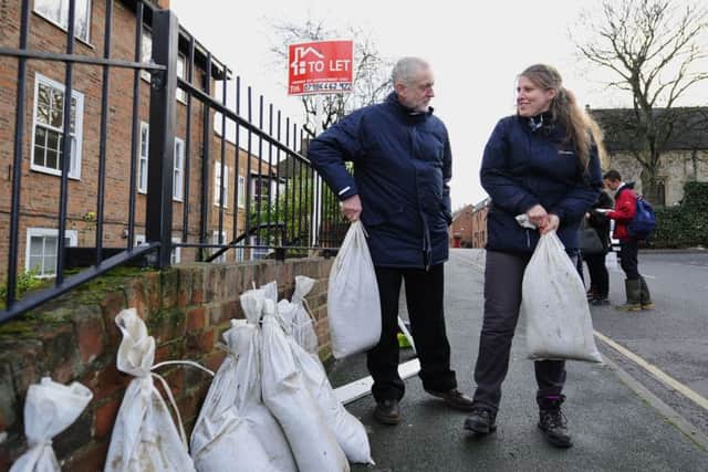 Labour leader Jeremy Corbyn and local Labour MP Rachael Maskell, lift some sandbags during his visit to view flood affected areas in York.