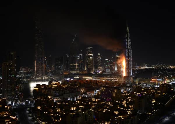 Smoke and flames pouring from a residential building, which also contains the Address Downtown Hotel, in Dubai, United Arab Emirates.  (Picture: Sina Bahrami/@dearsina via AP) MANDATORY CREDIT