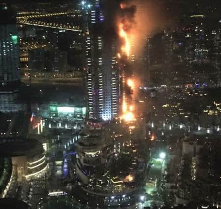In this photo provided by Trevor Hale, smoke and flames pour out from a residential building as a fire runs up some 20 stories of the high rise in Dubai. (Picture: Trevor Hale via AP)