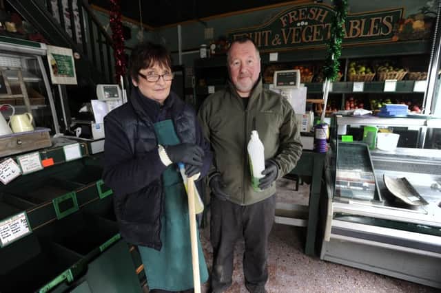 Bob and Maria Cowling of William Holt Greengrocers and Fish Merchants, cleaning up following the floods in Hebden Bridge on Boxing Day. Picture: Bruce Rollinson